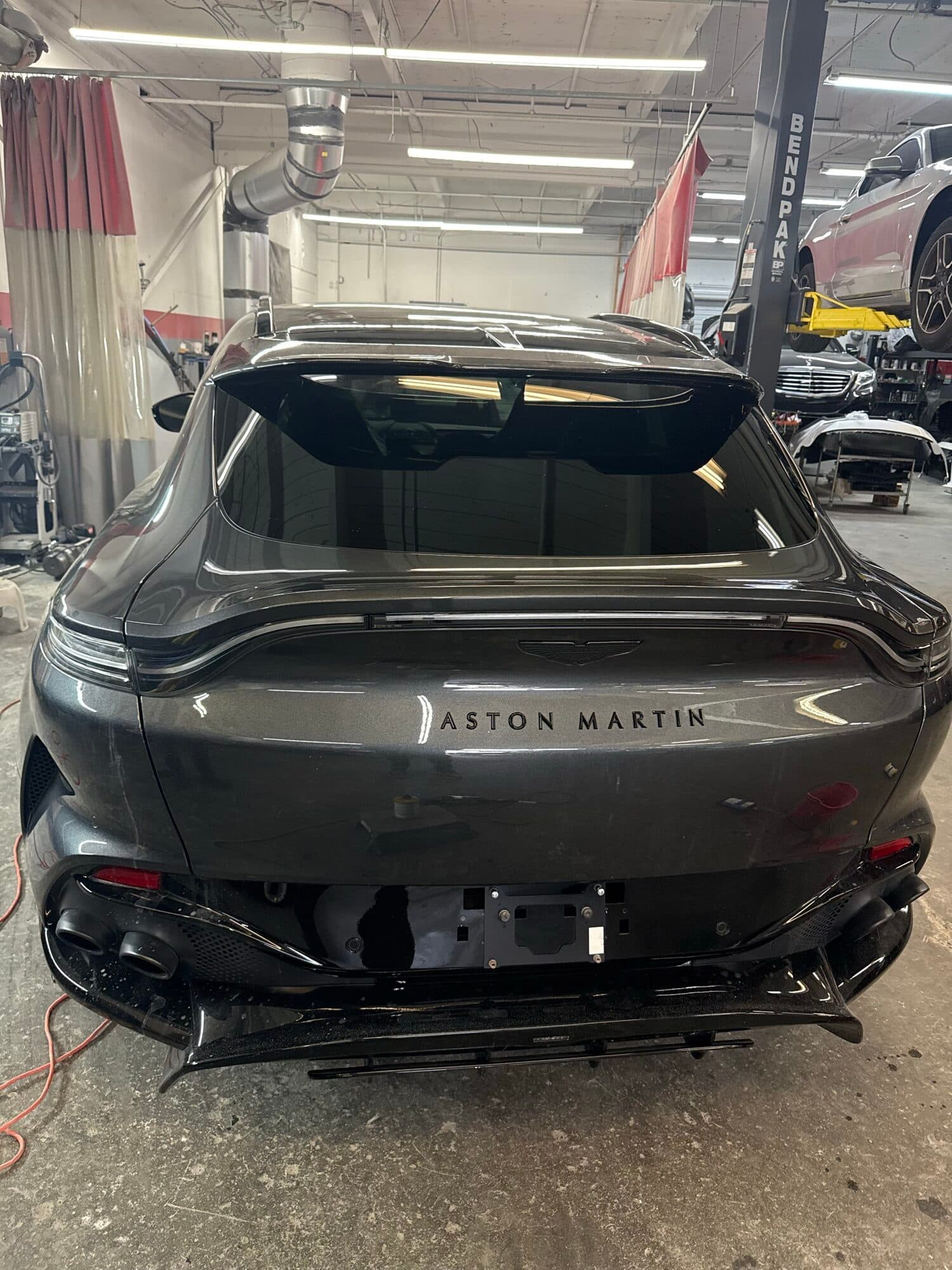 Aston Martin DBX up on the lift at Alpina Auto Body, Aston Martin repair and exotic body shop in Southeast Portland, Oregon