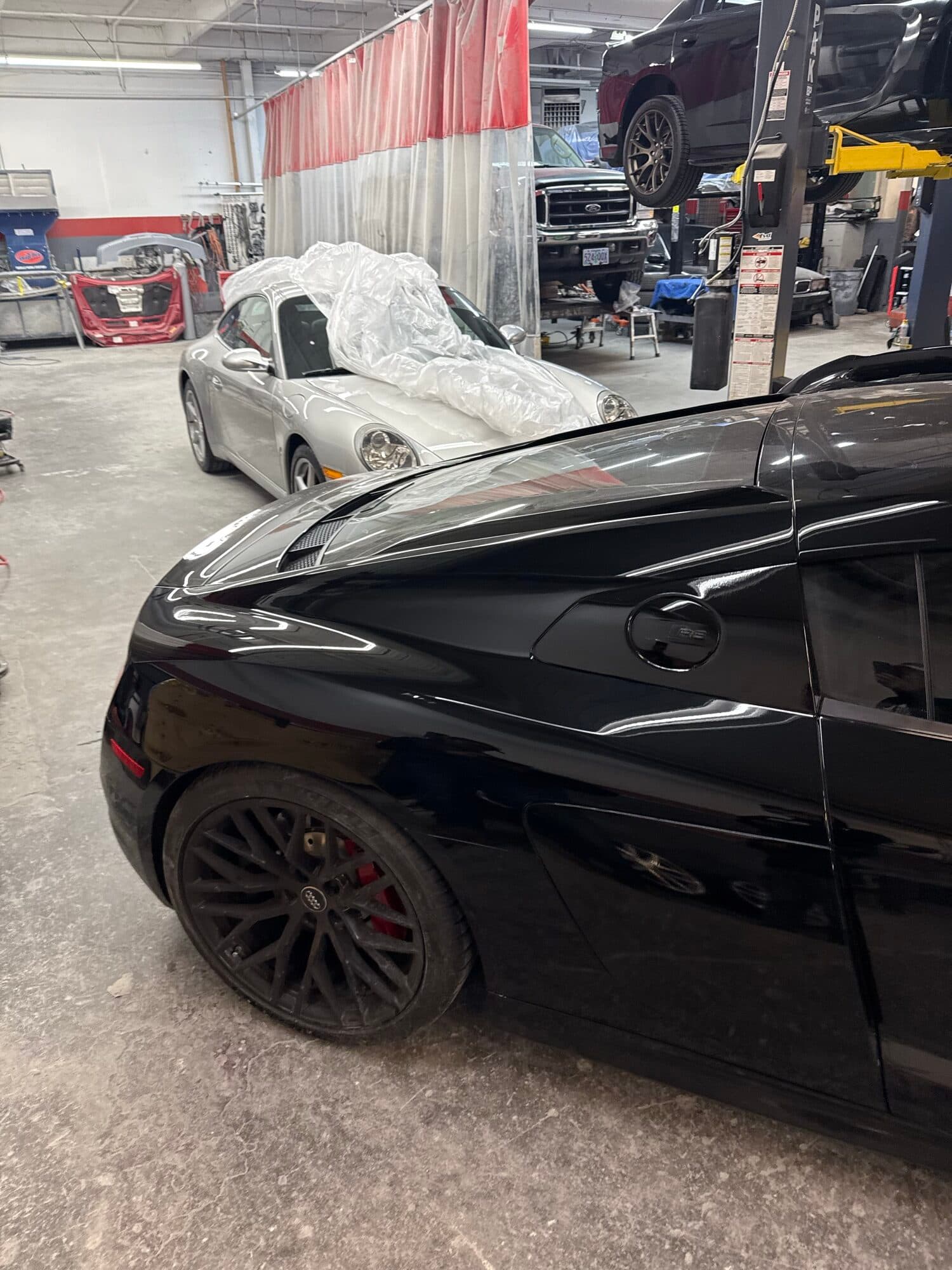 A close-up of a glossy carbon fiber weave panel refinished at Alpina Auto Body, Portland