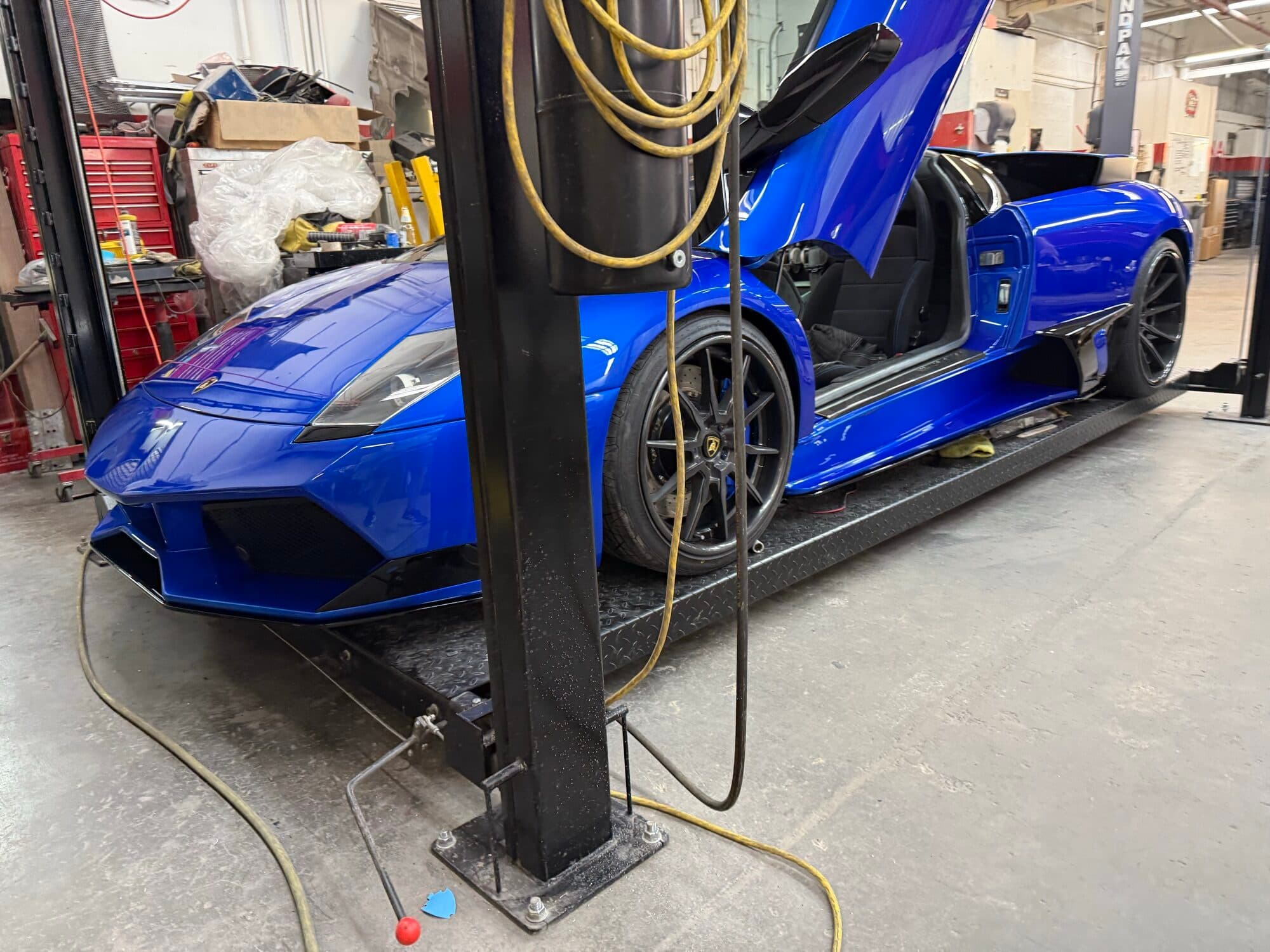 Blue Lamborghini Murcielago on the lift at Alpina Auto Body, Portland