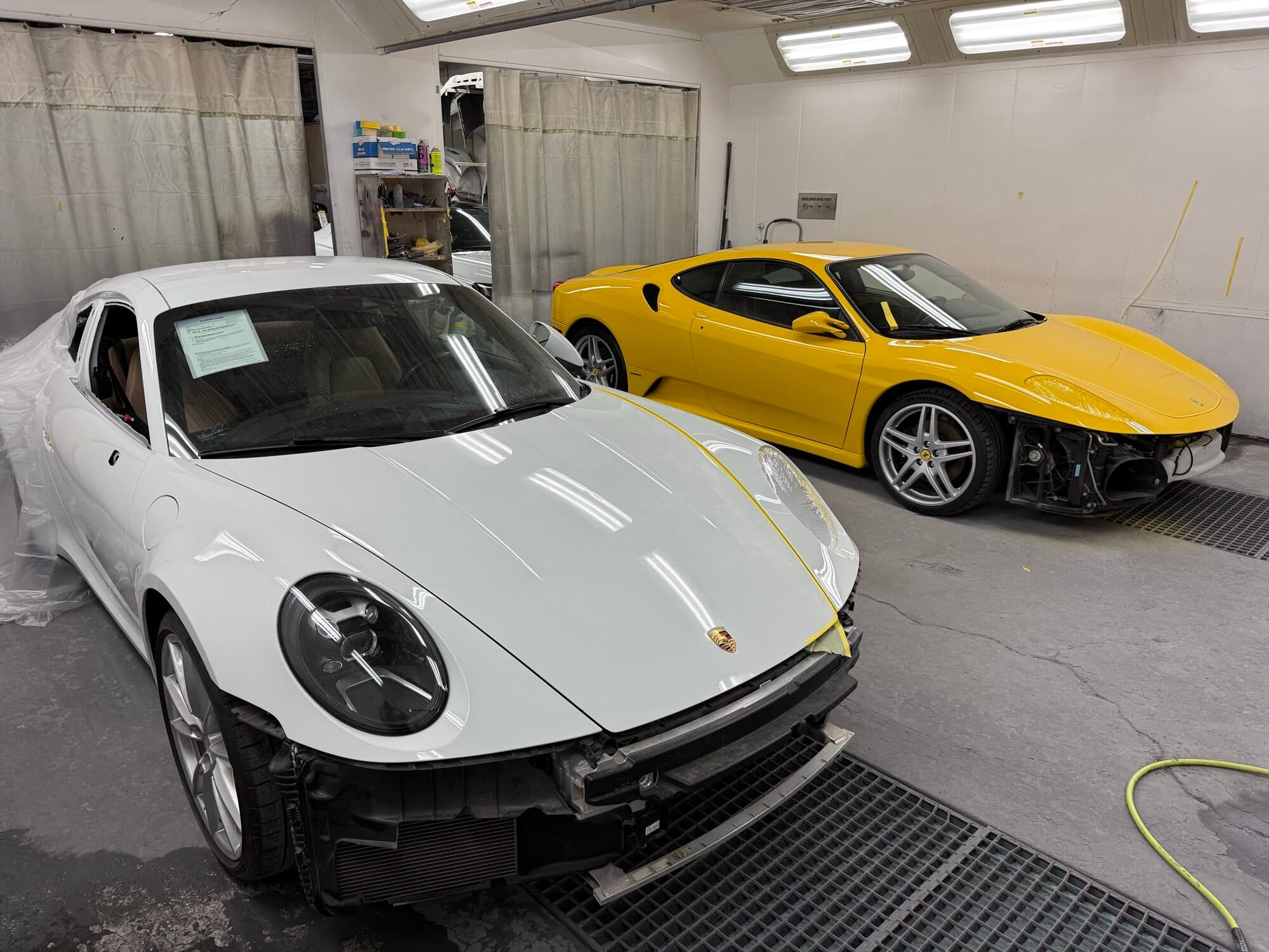 A finished white Porsche 911 in the booth at Alpina Auto Body, Portland