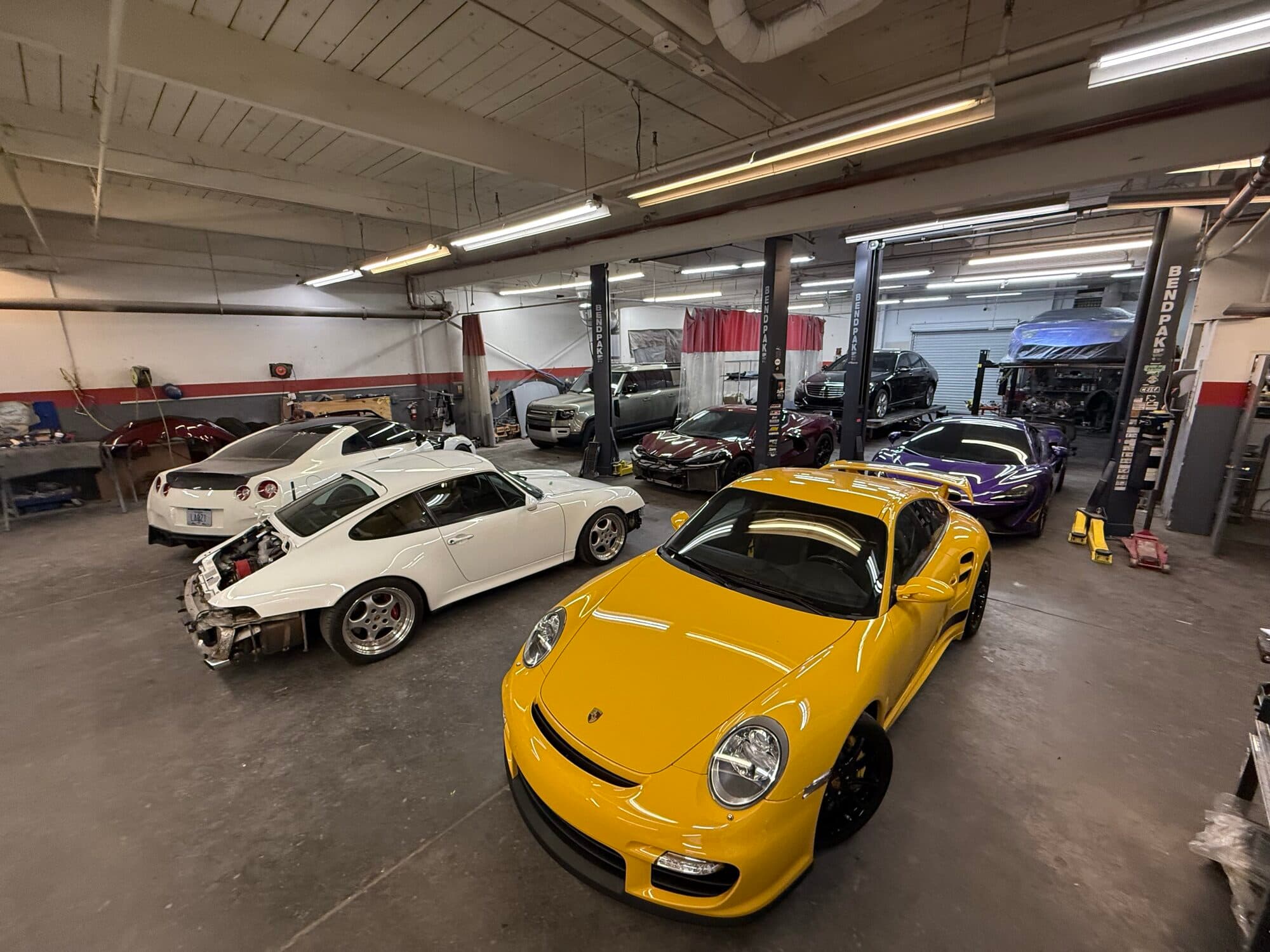 Exotics and a Porsche 911 GT2 RS on the floor at Alpina Auto Body, Southeast Portland