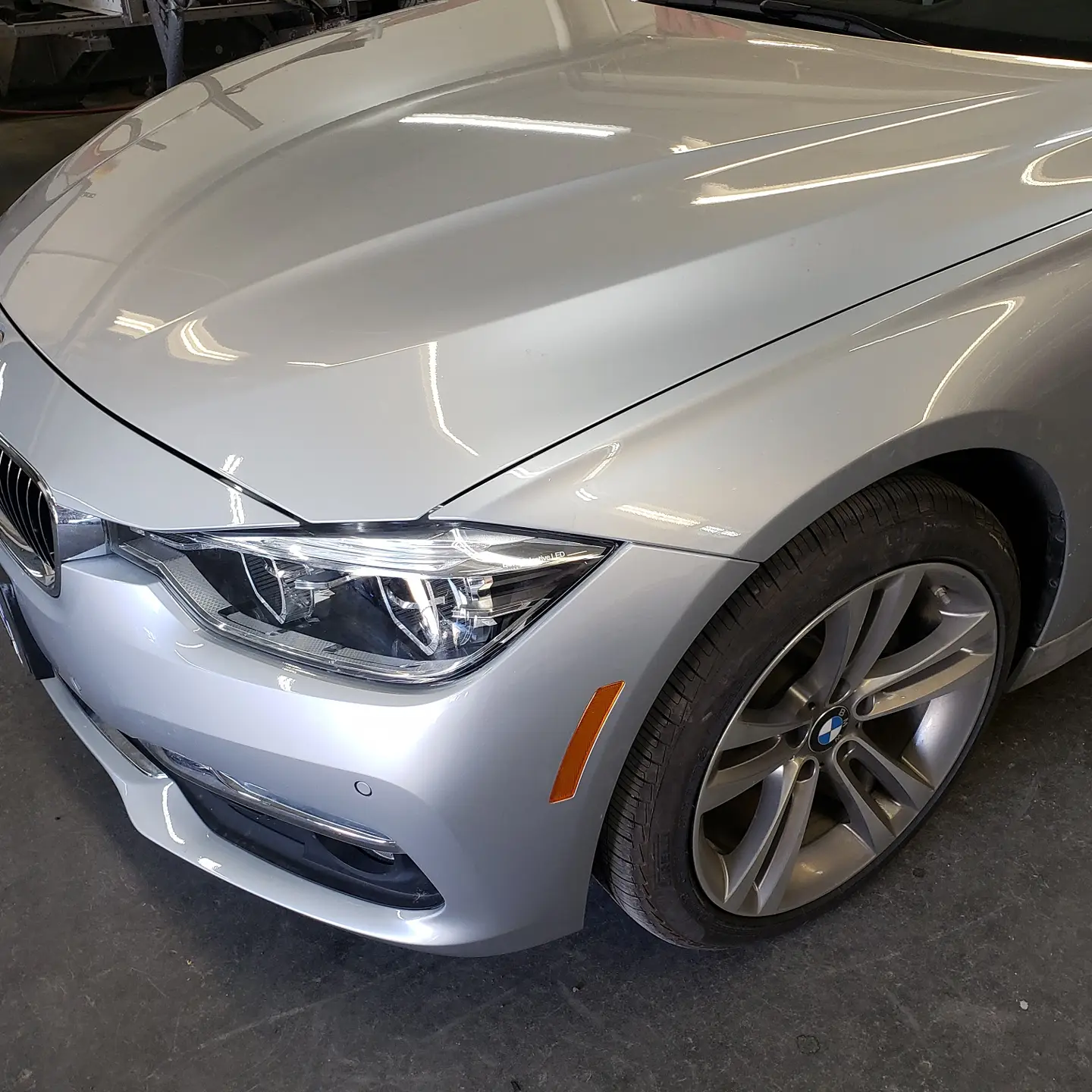 The same BMW 3 Series after fender and headlight repair and color-matched paint at Alpina